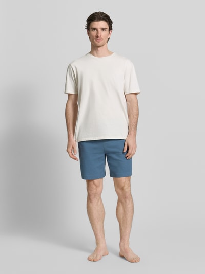 Männermodel trägt Regular Fit Sweatshorts aus Baumwoll-Mix Modell 'AUSTIN' von HUGO in Uni-Optik mit Label Stitching, Ganzkörperansicht von vorne.