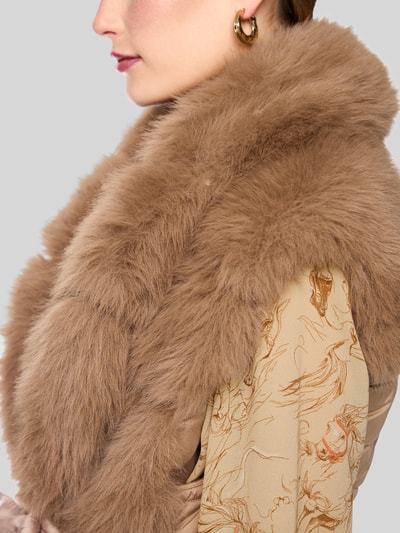 Frauenmodel trägt Weste aus Kunstfell mit Bindegürtel von Marc Cain in Beige, flauschige Textur, gemusterte Ärmel, Nahaufnahme Oberkörper. Rückenlänge 68 cm, Schulterbreite 46 cm, Brustweite 55 cm.