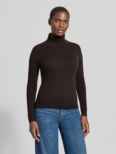 Frauenmodel trägt Regular Fit Rollkragenpullover aus reinem Kaschmir von Christian Berg Woman in Dunkelbraun, gerippter Kragen, Langarm, Ganzkörperansicht von vorne.