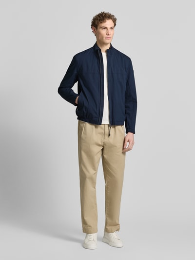 Männermodel trägt Jacke mit Stehkragen Modell 'Calvin' von Brax aus Baumwoll-Mix mit Stretch, navy, gerade geschnitten, Ganzkörperansicht von vorne.