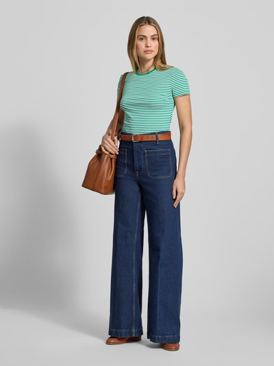 Frauenmodel trägt T-Shirt mit Rundhalsausschnitt Modell 'ALLI' von Lauren Ralph Lauren, grün-weiß gestreift, kombiniert mit Jeans, Ganzkörperansicht von vorne, Regular Fit aus Baumwoll-Elasthan-Mix, Rückenlänge bei Größe S 57 cm.