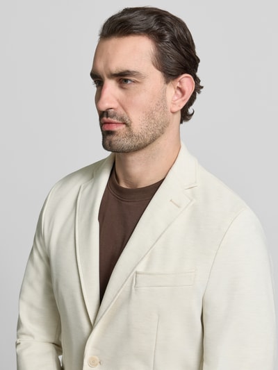 Männermodel trägt Slim Fit Sakko mit Viskose-Anteil Modell 'P-HANRY-J-WG-PK-261F' von BOSS in uni creme, Nahaufnahme Oberkörper.