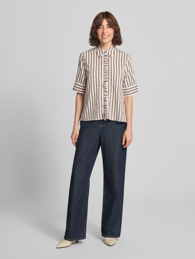 Modelka nosi Regular Fit Hemdbluse aus Viskose-Mix Model 'VICA FRIL' od Brax w dwukolorowe paski, krótki rękaw, twill, szerokie spodnie, zdjęcie całej sylwetki z przodu.