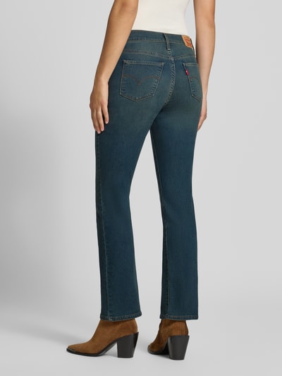 Frauenmodel trägt Straight Fit Jeans aus Baumwoll-Mix Modell '315®' von Levi's® 300 in Dunkelblau, dezente Waschung, Ganzkörperansicht Rückansicht.
