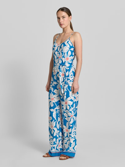 Vrouwenmodel draagt dames jumpsuit van zuiver viscose, getailleerd model, ronde hals, spaghettibandjes, strikceintuur, model 'Rylie' van GUIDO MARIA KRETSCHMER WOMAN met blauwe basis en witte bloemenprint, totale lengte 128 cm, borstwijdte 32 cm bij maat 36, binnenbeenlengte 78 cm, geheellichaamsaanzicht van voren.