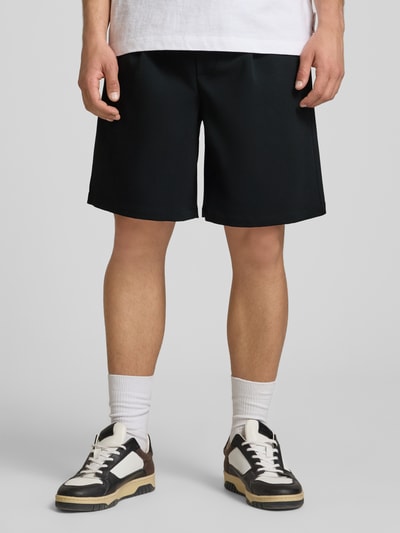 Männermodel trägt Loose Fit Shorts mit elastischem Bund Modell 'WILL' von Only & Sons, Optik: Unifarben, Bundfalte, Eingrifftaschen, Gesäßtasche, Ganzkörperansicht von vorne.