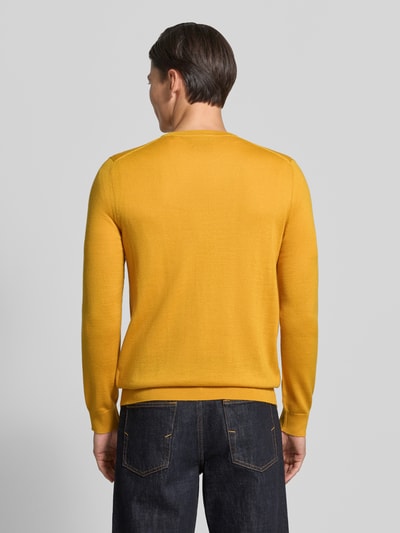 Männermodel trägt Strickpullover aus Woll-Mix mit V-Ausschnitt von Christian Berg Men in Gelb, Regular Fit, gerippte Abschlüsse, Ganzkörperansicht Rückansicht.