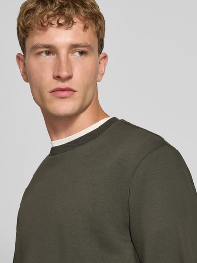 Männermodel trägt Regular Fit Sweatshirt aus Baumwoll-Mix Modell 'CERES' von ONLY in Dunkelgrün, glatte Oberfläche, Nahaufnahme Oberkörper, Herren Sweatshirt von ONLY & SONS.