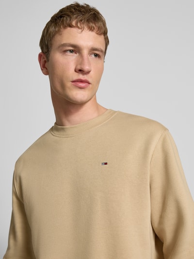 Männermodel trägt Regular Fit Sweatshirt aus Baumwoll-Mix von Tommy Jeans, Optik: Unifarben, Logo-Stitching, Nahaufnahme Oberkörper.