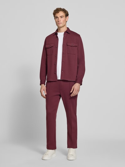Männermodel trägt Overshirt mit Knopfleiste von MCNEAL in Dunkelrot, Material-Mix mit Baumwoll-Anteil, Ganzkörperansicht von vorne.