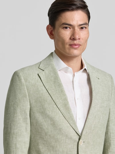 Männermodel trägt Sakko aus Leinen-Mix mit Pattentaschen von MCNEAL in hellem Grün, Leinen-Baumwoll-Mix, Modern Fit, Nahaufnahme Oberkörper. Reverskragen, Knopfleiste, Brusttasche, Pattentaschen, Rückenlänge 72 cm, Schulterbreite 45 cm, Ärmellänge 63 cm bei Größe 50.