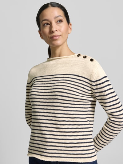 Frauenmodel trägt Regular Fit Strickpullover aus Baumwoll-Mix Modell 'QUADRO' von Weekend Max Mara, creme mit blauen Streifen, Knopf-Applikation, gestrickte Textur, Rundhals, Langarm, Ganzkörperansicht von vorne.