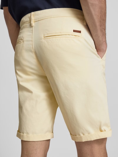 Männermodel trägt Straight Fit Shorts mit Eingrifftaschen Modell 'Bowie' von Jack & Jones aus Baumwoll-Mix, Gesäßtaschen, Nahaufnahme Rückansicht.