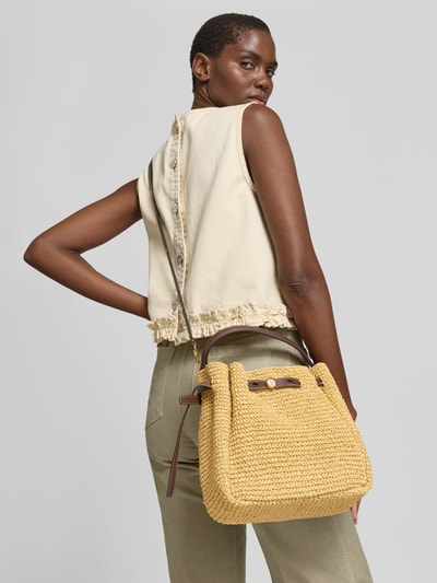 Männermodel trägt Bucket Bag aus Bast von Tory Burch in Beige mit braunem Henkel, Textur geflochten, Ganzkörperansicht Rückansicht, główna komora ze ściągaczem, regulowany pasek na ramię, krótka rączka, kieszeń wewnętrzna, Szerokość w rozmiarze 1: 26 cm, długość: 23 cm, głębokość: 11 cm.