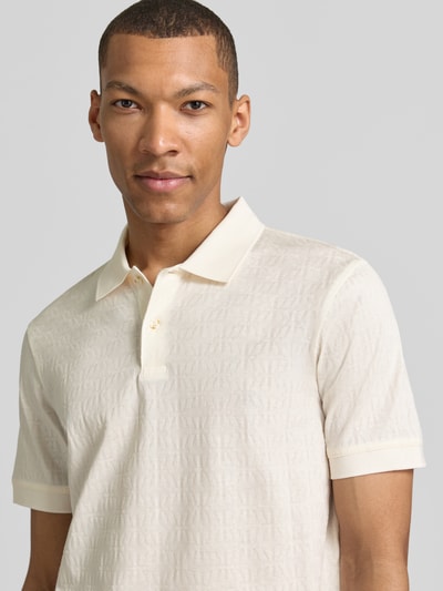 Männermodel trägt Modern Fit Poloshirt mit Strukturmuster Modell 'Roberto' von JOOP! Collection, Reine Baumwolle, Polokragen, Label-Detail, Nahaufnahme Oberkörper.
