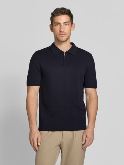 Männermodel trägt Regular Fit Poloshirt mit Reißverschluss Modell 'MILANO' von Jack & Jones Premium in Dunkelblau, Ganzkörperansicht von vorne, Bio-Baumwoll-Mix, kurzer Reißverschluss, Polokragen, Label-Detail, glatte Textur
