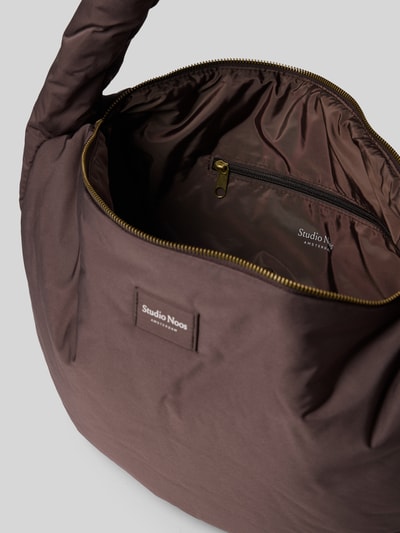 Produktfoto, braune Shoulder Bag mit Logo-Detail Modell 'Puffy' von Studio Noos mit Reißverschluss, weiche Struktur, sichtbares Hauptfach