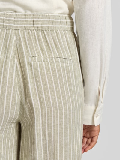 Frauenmodel trägt Relaxed Fit Weite Hose aus Leinen-Viskose-Mix von s.Oliver RED LABEL, Optik: Unifarben, Bundfalte, Bundabschluss elastisch mit Tunnelzug, Gesäßtasche, Nahaufnahme Rückansicht.