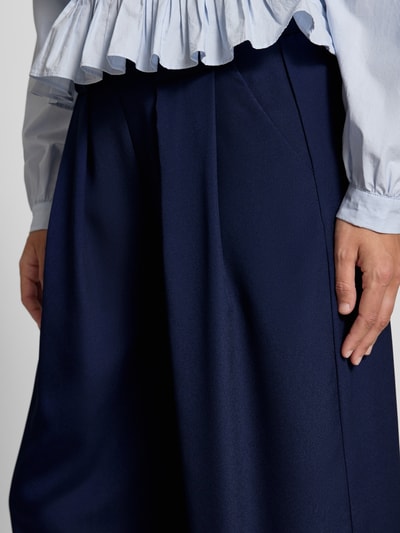 Frauenmodel trägt Wide Leg Hose mit elastischem Bund von Rich & Royal, dunkelblau mit Gelegte Falten, Eingrifftaschen, Nahaufnahme Oberkörper.