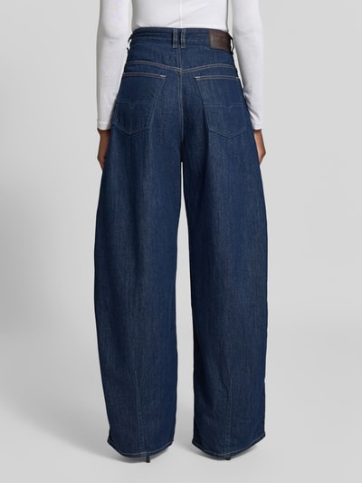 Frauenmodel trägt Balloon Fit Jeans aus reiner Baumwolle von Diesel in Dunkelblau mit Kontrastnähten, 5-Pocket-Design, Ganzkörperansicht Rückansicht.