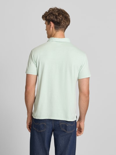 Männermodel trägt Slim Fit Poloshirt mit Brusttasche von Superdry aus Baumwoll-Leinen-Mix, hellgrün, Rückenlänge 67 cm, Ganzkörperansicht Rückansicht.