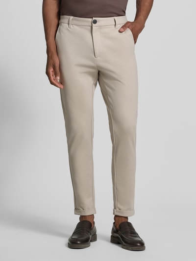 Männermodel trägt Slim Fit Stoffhose mit umgeschlagenen Hosenbeinen von Lindbergh in Beige, elastischer Material-Mix, Nahaufnahme Oberkörper, Bundweite 43 cm, Innenbeinlänge 73 cm, KI-modifiziertes Bild.