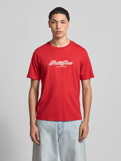 Männermodel trägt Regular Fit T-Shirt mit Logo-Print von JACK & JONES in Rot, reine Baumwolle, Rundhalsausschnitt, Ganzkörperansicht von vorne. Rückenlänge bei Größe M: 69 cm.