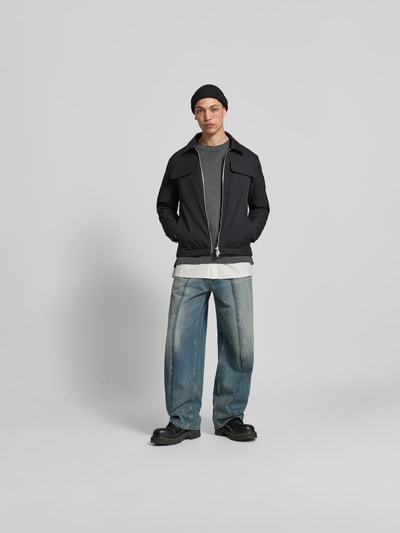 Männermodel trägt Jacke mit Umlegekragen von Moose Knuckles, gerade Passform, Zweiwege-Reißverschluss, Label-Patch, Ganzkörperansicht von vorne. Rückenlänge 67 cm, Schulterbreite 47 cm, Ärmellänge 66 cm, Brusttaschen, dunkle Farben, glatte Textur.