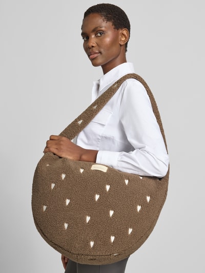 Kobiece modelka nosi Crossbody Bag aus Teddyfell od Studio Noos z futerka, detal z logo, wyhaftowany motywem na całej powierzchni, Główna przegroda z zamkiem błyskawicznym, pasek na ramię, Szerokość w rozmiarze 1: 50 cm, Długość w rozmiarze 1: 37 cm, Głębokość w rozmiarze 1: 11 cm, długość paska na ramię w rozmiarze 1: 86 cm, brązowy, kremowe detale, tekstura miękka, Ganzkörperansicht z przodu.