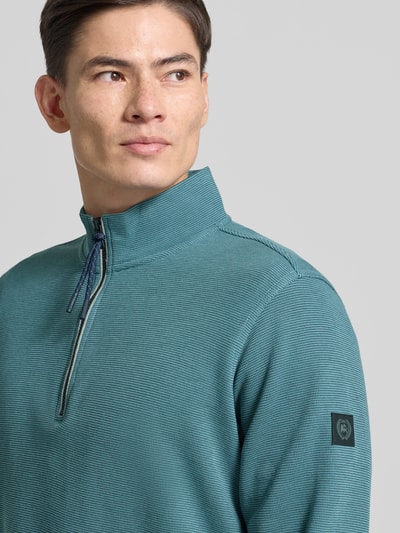 Męski model nosi Regular Fit Troyer mit Stehkragen und Reißverschluss od Lerros w kolorze morskim, strukturalny wzór, zbliżenie na górę.