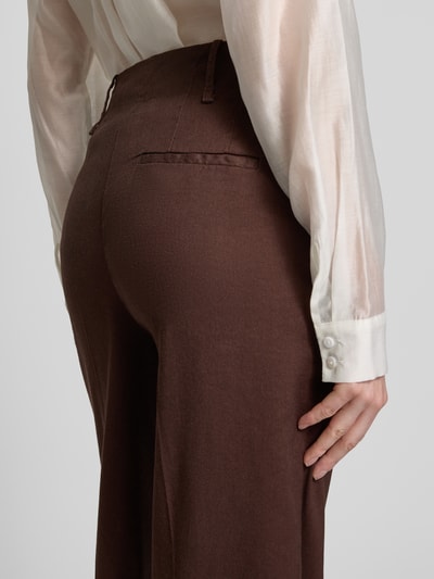 Frauenmodel trägt Straight Fit Leinenhose mit Viskose-Anteil von Stefanel, braun, glatte Textur, mit Bügelfalten und Eingrifftaschen, Nahaufnahme Rückansicht.