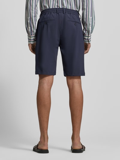 Mężczyzna nosi Straight Fit Shorts mit elastischem Bund von CRUNA, kolor granatowy, kieszenie z tyłu, szerokość w rozmiarze 50: 42 cm, długość wewnętrzna nogawki 26 cm, całkowity widok z tyłu.