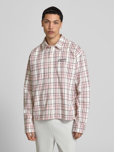Männermodel trägt Oversized Freizeithemd mit Label-Stitching Modell 'Soglio' von Pegador aus Reine Baumwolle im Karo-Design, Nahaufnahme Oberkörper. Rückenlänge 62 cm, Schulterbreite 58 cm, Ärmellänge 67 cm, Kentkragen, Oversized-Schnitt.