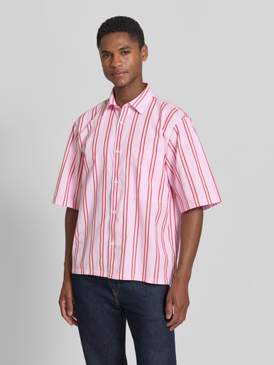 Männermodel trägt Regular Fit Freizeithemd mit Kentkragen und Brusttasche von Lindbergh, rosa mit roten Streifen, reine Baumwolle, Ganzkörperansicht von vorne.