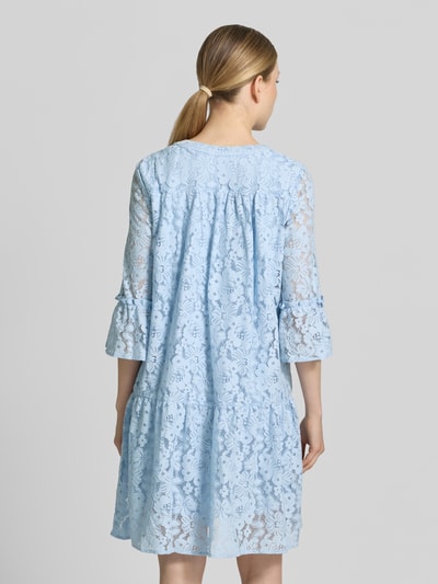Frauenmodel trägt Loose Fit Spitzenkleid aus Baumwoll-Mix Modell 'HONEY' von Vero Moda, Optik: Unifarben, Spitzen-Muster, knielang, V-Ausschnitt, 3/4-Arm mit Glockenärmel, Materialverarbeitung: Spitze, Farbe Hellblau, Ganzkörperansicht Rückansicht.