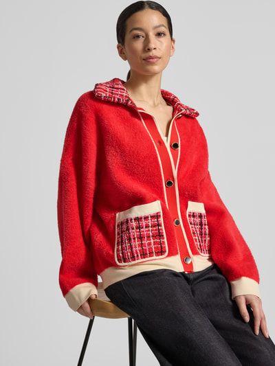 Vrouwenmodel draagt Boxy Fit Strickjacke mit Ripp-Bündchen Modell 'JOILU' van Essentiel Antwerp in colorblocking-look, voorkant volledig zichtbaar, ganzkörperansicht van voren.