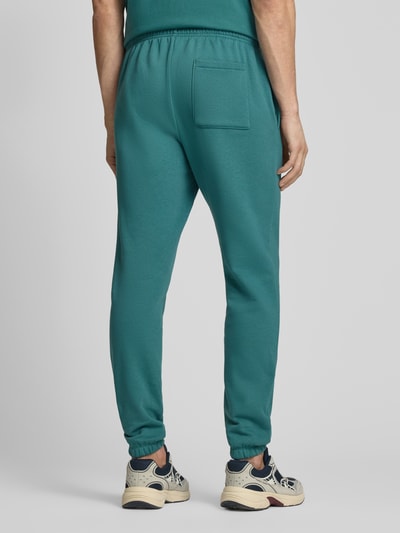 Männermodel trägt Sweatpants mit elastischem Bund von GAP in Türkis, Baumwoll-Mix, Regular-Fit, Gesäßtasche, Ganzkörperansicht Rückansicht. Innenbeinlänge bei Größe M: 74 cm.