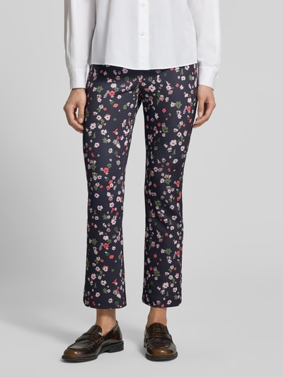 Kobiece model nosi Flared Fit Leggins in verkürzter Passform od Marc Cain, elastyczna mieszanka materiałów, rozkloszowany krój, skrócony fason, elastyczny pas, szerokość w rozmiarze 36: 36 cm, długość wewnętrzna nogawki w rozmiarze 36: 69 cm, wzór kwiatowy, ciemne tło, prosta faktura, całkowite ujęcie z przodu.