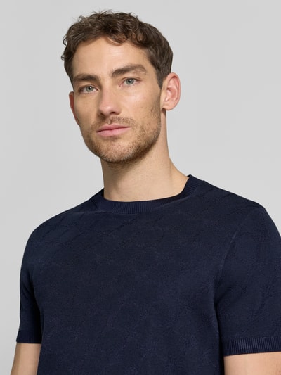 Männermodel trägt Herren T-Shirt mit Viskose-Anteil und Rundhalsausschnitt Modell 'Ravao' von JOOP! Collection, Dunkelblau, Nahaufnahme Oberkörper. Baumwoll-Viskose-Mix, Modern Fit, Label-Detail, Rückenlänge bei Größe M 69 cm.