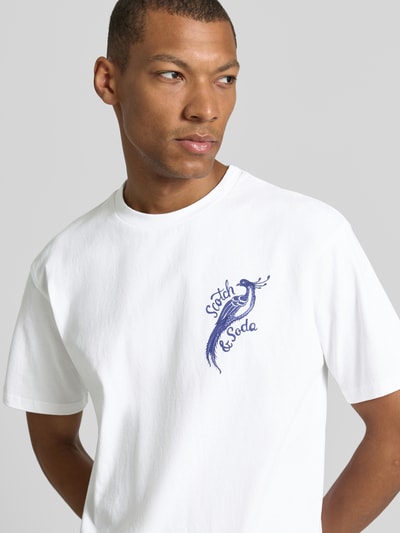 Männermodel trägt Oversized T-Shirt mit Logo-Stitching von Scotch & Soda, reine Baumwolle, Weiß, Nahaufnahme Oberkörper.