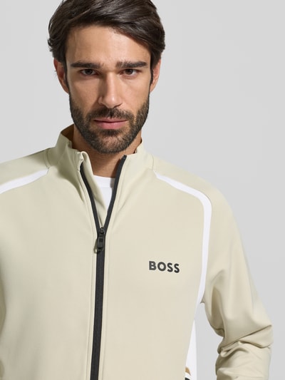 Männermodel trägt Regular Fit Trainingsjacke mit Passeinsätzen Modell 'TOC SPIN FZ' von BOSS Green, Optik: Unifarben, Twill, Nahaufnahme Oberkörper.