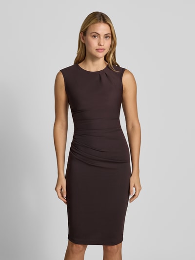 Frauenmodel trägt Cocktailkleid mit Raffungen von Rinascimento in dunklem Braun, knielang, taillierte Passform, Ganzkörperansicht von vorne.