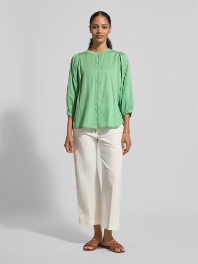 Frauenmodel trägt Regular Fit Bluse mit Rundhalsausschnitt Modell 'FAVIOLA' von 0039 Italy aus reiner Baumwolle in Grün, 3/4-Arm, Ganzkörperansicht von vorne.