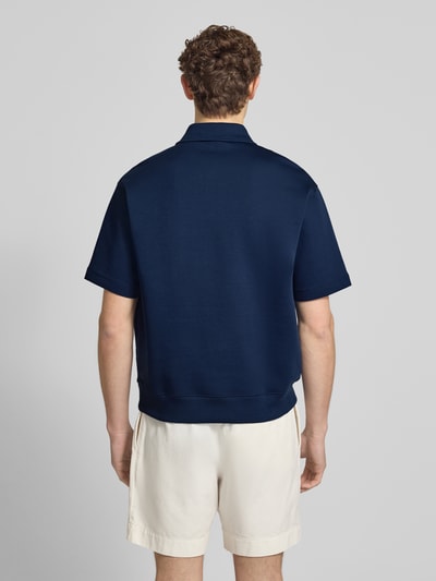 Männermodel trägt Loose Fit Poloshirt mit Label-Stitching von ARMANI EXCHANGE aus Baumwoll-Mix mit Stretch-Anteil, Ganzkörperansicht Rückansicht.