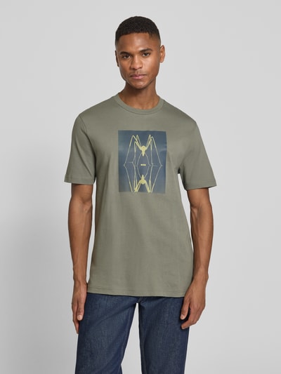 Männermodel trägt Regular Fit T-Shirt aus reiner Baumwolle Modell 'TE_CREATURE' von BOSS Orange, unifarbenes Jersey mit Motiv-Print, Ganzkörperansicht von vorne.