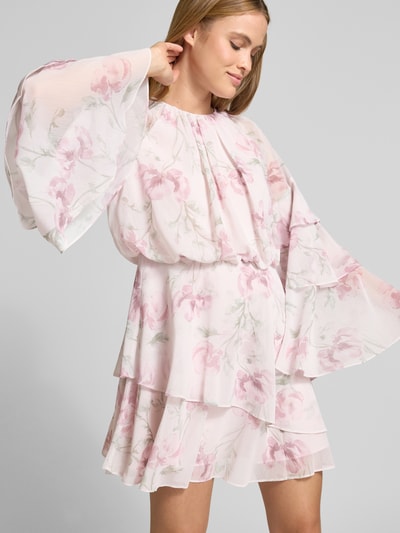Modelka nosi sukienkę mini z szyfonu, taliowany krój, model 'MAHLIIA' od Ted Baker, okrągły dekolt, szerokie rękawy, dół obszyty falbaną, z wycięciem w kształcie łezki i zamkiem błyskawicznym z tyłu, pastelowe kwiaty, tekstura lekko transparentna, widoczne warstwy, długość tyłu w rozmiarze 36: 39 cm, szerokość w rozmiarze 36: 44 cm, długość rękawów w rozmiarze 36: 46 cm, ujęcie: całkowity widok z przodu.