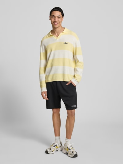 Männermodel trägt Regular Fit Shorts mit Label-Stitching von REVIEW aus Baumwoll-Mix in Schwarz, elastischer Bund, Ganzkörperansicht von vorne.