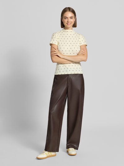 Frauenmodel trägt Weite Hose in Lederoptik Modell 'NELI' von ONLY in Dunkelbraun, kombiniert mit hellem, gepunkteten Shirt, Ganzkörperansicht von vorne, Damen Weite Hose von ONLY.