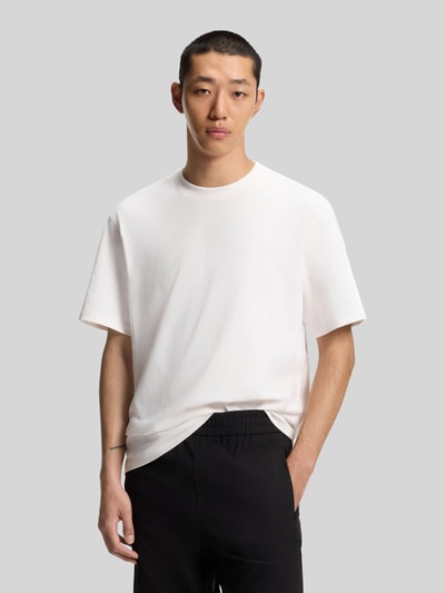 Männermodel trägt Relaxed Fit T-Shirt aus reiner Baumwolle Modell 'DAPOLINO' von HUGO, unifarben, Label Print, Ganzkörperansicht von vorne.