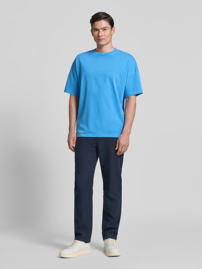 Männermodel trägt Herren T-Shirt mit geripptem Rundhalsausschnitt Modell 'FIZVALLEY' von American Vintage in Blau, Reine Baumwolle, Loose-Fit, Rückenlänge bei Größe M/L 72 cm, Ganzkörperansicht von vorne.